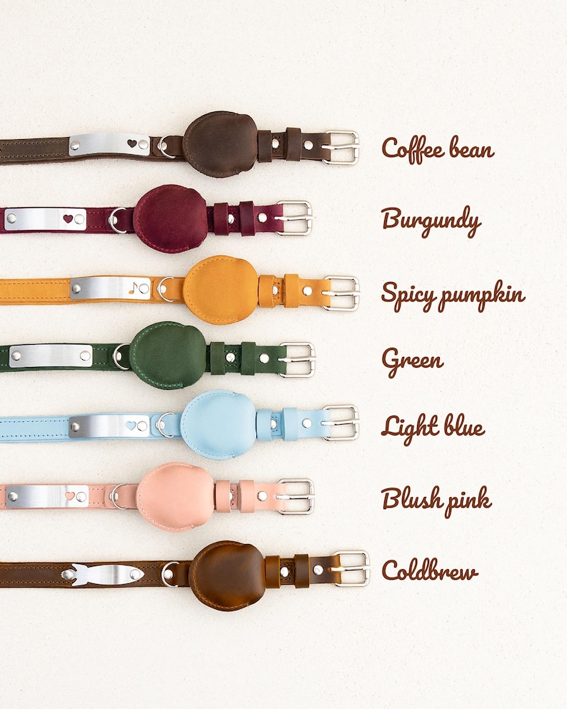 Op de afbeelding: Een collectie leren hondenhalsbanden in diverse kleuren, waaronder koffieboon, bordeauxrood, spicy pumpkin, groen, lichtblauw, blush roze en coldbrew. Elke halsband heeft een metalen naamplaatje en een cirkelvormig leren detail.