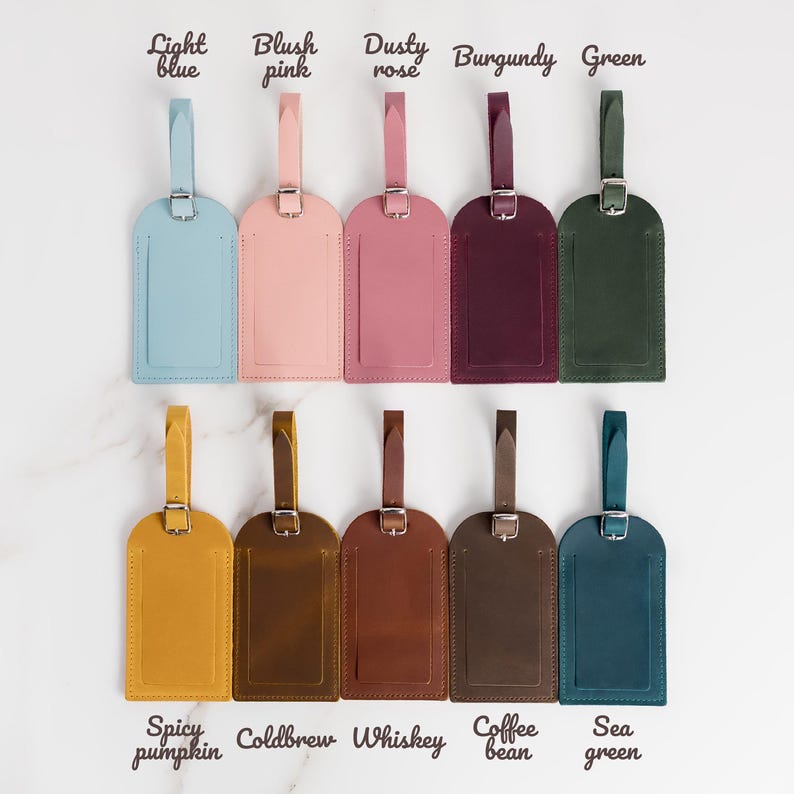 May include: Ten leather luggage tags in various colors, including light blue, blush pink, dusty rose, burgundy, green, spicy pumpkin, cold brew, whiskey, coffee bean, and sea green. Each tag has a loop for attaching to luggage.