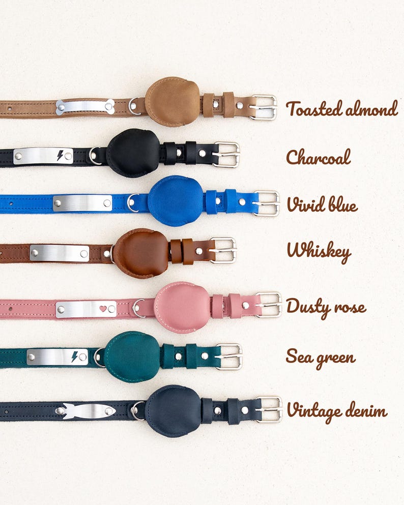 Op de afbeelding: Een collectie leren hondenhalsbanden in diverse kleuren, waaronder geroosterde amandel, houtskool, helderblauw, whisky, stoffig roze, zeegroen en vintage denim. Elke halsband heeft een metalen naamplaatje en een bijpassend leren accent.