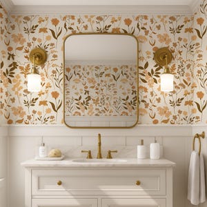 Puede incluir: Un mueble de baño con espejo con marco dorado, grifería dorada y encimera blanca. Las paredes están decoradas con papel pintado floral en tonos marrón y crema. Dos apliques con pantallas de cristal blanco flanquean el espejo.