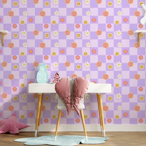 May include: A room with a purple and white checkered wallpaper pattern featuring smiley faces, daisies, and the words "Good Vibes". A white desk with wooden legs holds pink heart-shaped pillows. Decorative shelves hold a unicorn and ice cream cones.