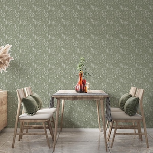 May include: A dining room scene featuring a wooden table and chairs, adorned with decorative elements. The table is set with a vase of flowers and a decorative runner. The chairs have green cushions. The wallpaper has a floral pattern.