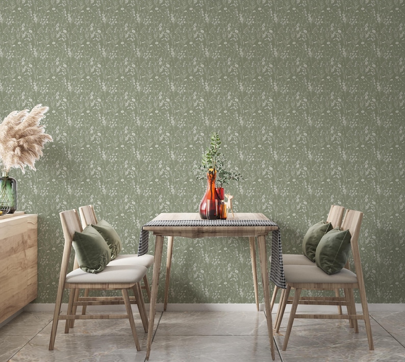May include: A dining room scene featuring a wooden table and chairs, adorned with decorative elements. The table is set with a vase of flowers and a decorative runner. The chairs have green cushions. The wallpaper has a floral pattern.