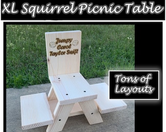 May include: A wooden squirrel picnic table with two benches. The table is unfinished and has a sign on the back that says "Jumpy Carol Taylor Swift".