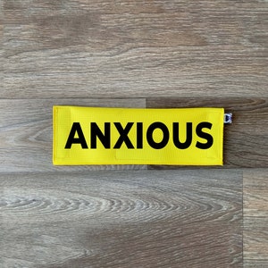 May include: Yellow fabric patch with black text that reads "ANXIOUS".