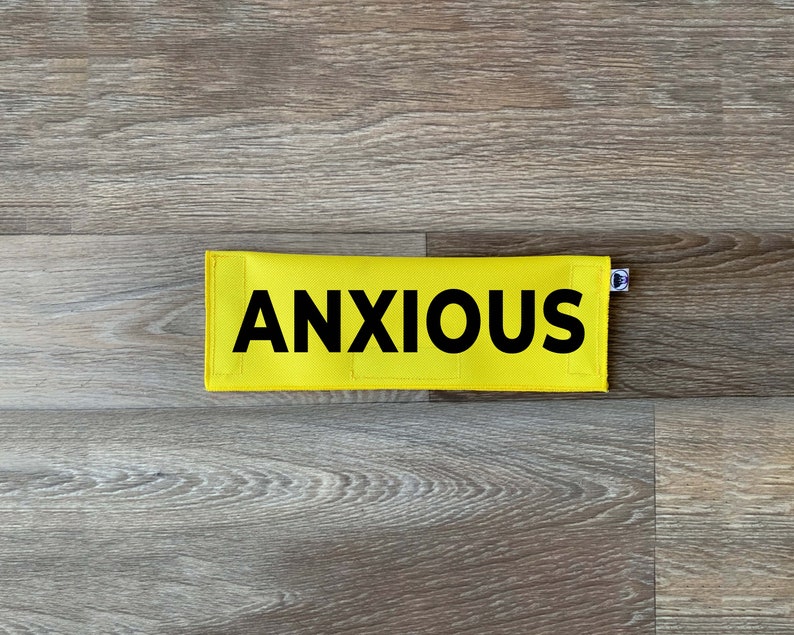May include: Yellow fabric patch with black text that reads "ANXIOUS".