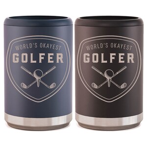 May include: Two stainless steel can coolers in black and blue. Both coolers feature a white graphic of crossed golf clubs and a golf ball with the text "World's Okayest Golfer".