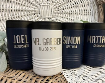 May include: Four insulated beverage holders with personalized names and titles. The holders are navy blue and white with silver lettering. The names are Joel, Mr. Garber, Simon, and Matthias. The titles are "Groomsman", "Best Man", and "Groomsman".