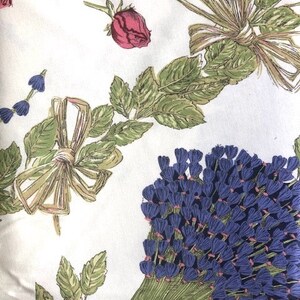 Puede incluir: Tela blanca con un patr&oacute;n floral con flores azules, verdes y rosas. La tela tiene una est&eacute;tica vintage y ser&iacute;a adecuada para proyectos de manualidades.