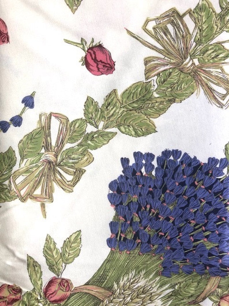 Puede incluir: Tela blanca con un patr&oacute;n floral con flores azules, verdes y rosas. La tela tiene una est&eacute;tica vintage y ser&iacute;a adecuada para proyectos de manualidades.