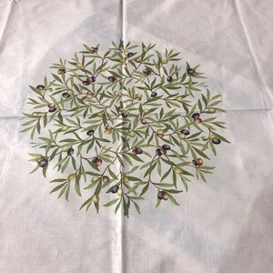 Puede incluir: Tela blanca con un dise&ntilde;o circular de ramas de olivo con hojas verdes y aceitunas negras, moradas y verdes.
