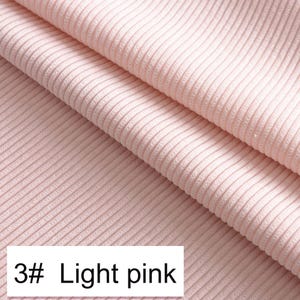 May include: A light pink fabric featuring a distinct vertical ribbed texture. The material is folded to show depth and dimension. A white rectangular label in the bottom left corner displays the black text 3# Light pink, identifying the color.