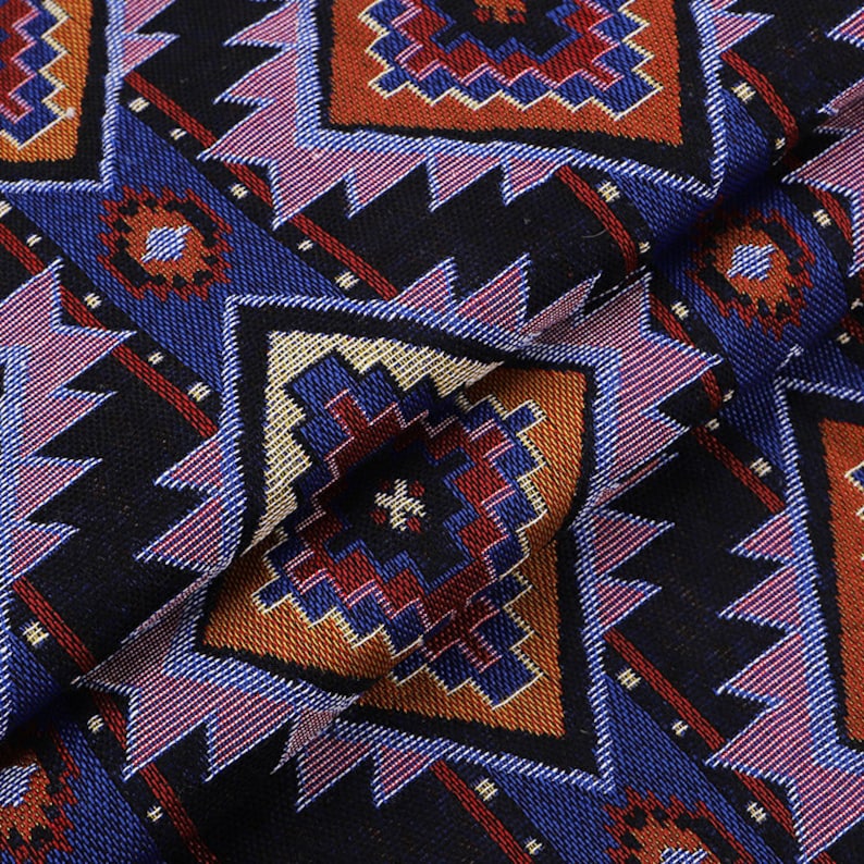 Peut inclure: Tissu noir avec un motif g&eacute;om&eacute;trique dans des tons de bleu, rouge, orange et blanc. Le motif est compos&eacute; de diamants et de triangles r&eacute;p&eacute;t&eacute;s.