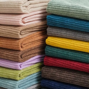 Può includere: Un mucchio di 14 campioni di tessuto a costine di diversi colori. I campioni sono disposti in una pila verticale, con il colore più chiaro in cima e il colore più scuro in fondo. I colori includono beige, rosa, verde, blu, grigio, giallo, marrone, viola, verde chiaro, verde scuro, blu chiaro, blu scuro, nero e marrone.