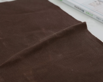 Peut inclure: Un gros plan sur un tissu brun avec une surface texturée.
