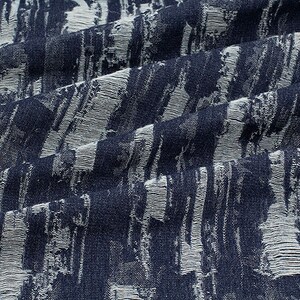 May include: A close-up of a blue and white fabric with a textured, brushstroke pattern.