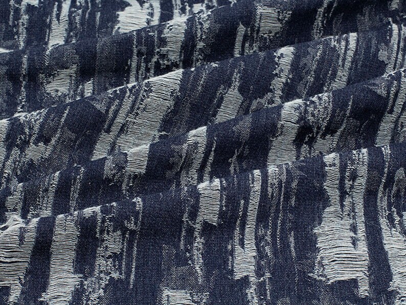 May include: A close-up of a blue and white fabric with a textured, brushstroke pattern.
