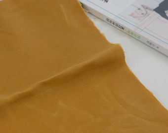 Peut inclure: Gros plan sur un tissu jaune moutarde à texture côtelée.