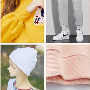 May include: A collage of fashion items. A yellow sweatshirt with a patch, gray sweatpants, white sneakers with black swooshes, a white beanie, and a pink sweatshirt cuff.