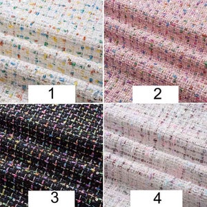 May include: Four samples of tweed fabric with different color combinations. The first sample is white with multi-colored flecks. The second sample is pink with multi-colored flecks. The third sample is black with multi-colored flecks. The fourth sample is white with pink and multi-colored flecks.