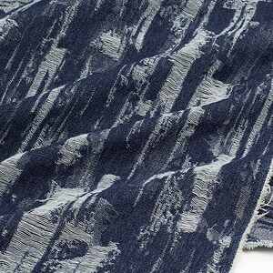 May include: Close-up of a blue and white textured fabric with a frayed edge. The fabric has a vertical striped pattern.