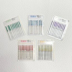 May include: Five clear plastic packages of sewing needles. Each package contains 12 needles and has a label with the text "防跳针" and a size. The sizes are 65/9, 75/11, 90/14, 100/16. The needles are arranged in rows and are all the same size. The needles are silver in color and have a black tip.