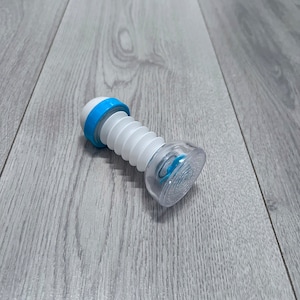 May include: A white and blue flexible faucet aerator with a clear, textured end. The aerator has a blue ring at the top and a corrugated, accordion-like body. The clear end has a blue accent.