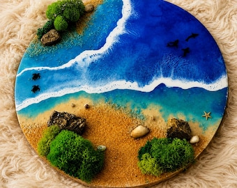 Könnte beinhalten: Ein kreisförmiges Wandbild mit einer Ozeanszene aus Harz, bestehend aus einem Sandstrand, weißen Schaumwellen und tiefblauem Wasser. Das Design enthält grüne Moosbüschel, kleine Steine, einen Seestern sowie Silhouetten von Meeresschildkröten und Delfinen.