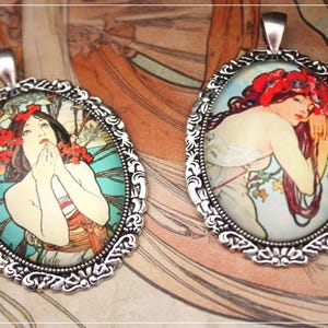 Peut inclure: Deux pendentifs ovales avec des cadres en filigrane argentés. Chaque pendentif présente une illustration colorée de style Art nouveau d'une femme avec des fleurs rouges dans les cheveux. Le fond est un mélange de turquoise, d'orange et de crème.