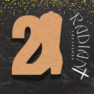May include: A wooden number 2 cutout with a light brown finish. The number is positioned on a black marble-like surface with gold glitter accents. The text "Radiant Creations" is written in white cursive.