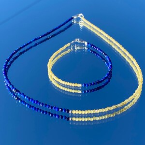 May include: A set of two necklaces, one blue and one yellow, made of gemstone beads. The blue necklace is made of lapis lazuli beads and the yellow necklace is made of citrine beads.