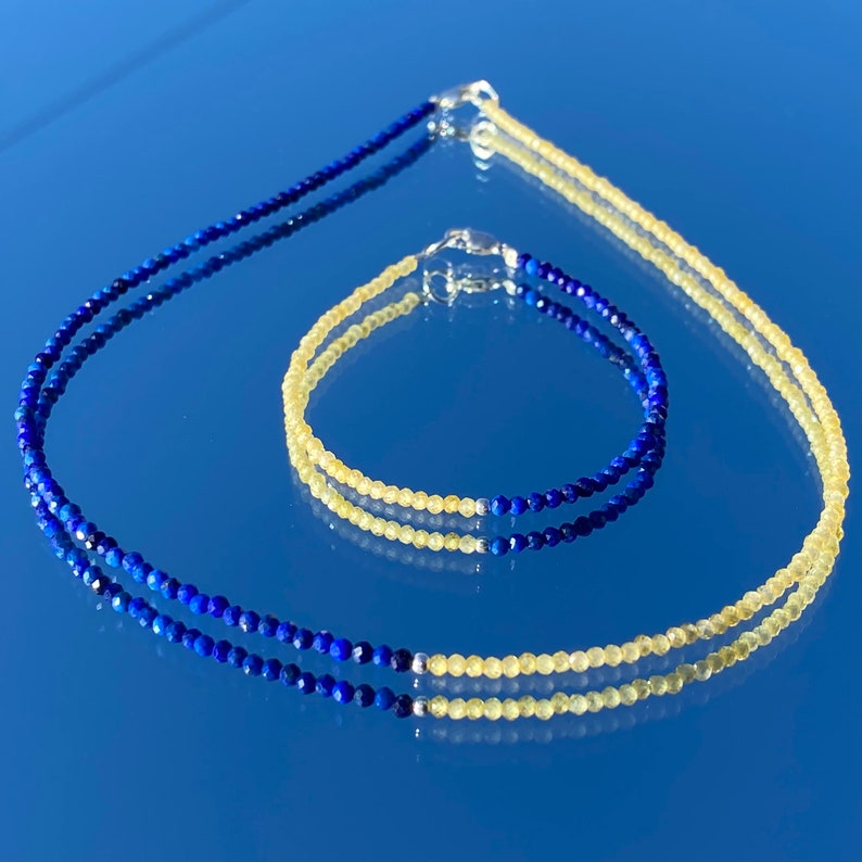 May include: A set of two necklaces, one blue and one yellow, made of gemstone beads. The blue necklace is made of lapis lazuli beads and the yellow necklace is made of citrine beads.