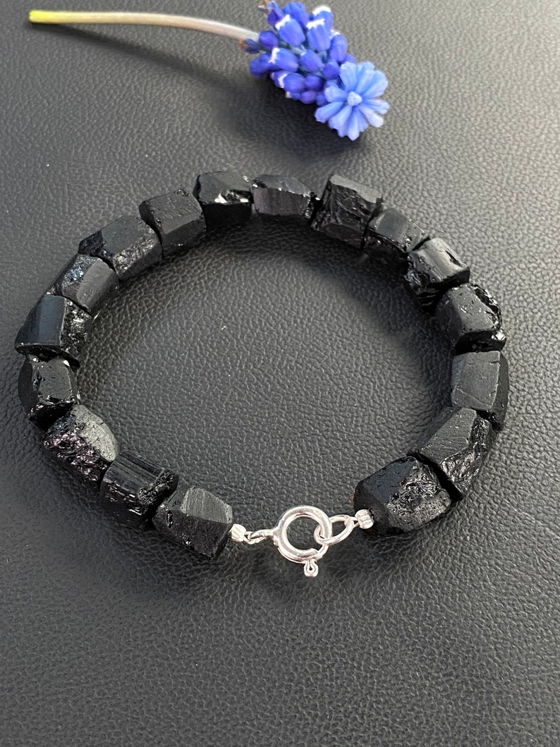 May include: Black Tourmaline bracelet made with rough, natural stones. The bracelet has a silver clasp.