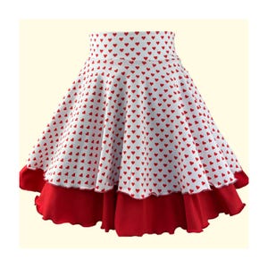 Puede incluir: Una falda blanca con estampado de corazones rojos y un dobladillo rojo con volantes.