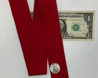 May include: Red herringbone ribbon, approximately 1 inch wide, next to a US dollar bill for size comparison.
