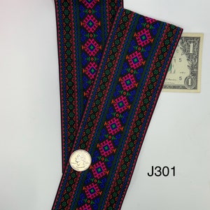 May include: Black elastic trim with a colorful geometric pattern in shades of pink, green, blue, and orange. The trim has a repeating design of diamonds and squares. The trim is labeled J301.