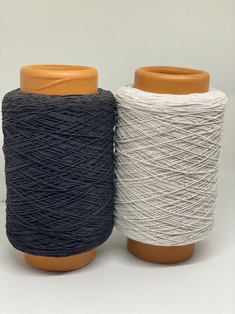 May include: Two spools of elastic cord, one black and one white, with brown wooden spools.