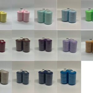 May include: A collection of 15 spools of thread in various colors, including yellow, pink, light blue, green, red, brown, purple, lavender, beige, navy blue, and teal. Each spool is labeled with a number.