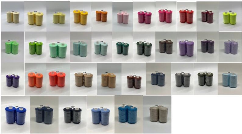 May include: A collection of 30 spools of thread in various colors, including yellow, green, orange, pink, purple, brown, blue, and beige. The spools are arranged in rows of six.
