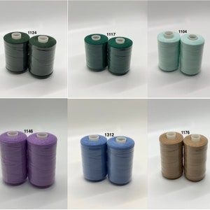 May include: Six spools of thread in different colors. The spools are labeled with numbers: 1124, 1117, 1104, 1146, 1312, and 1176.
