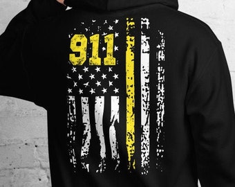 May include: Black hoodie featuring a distressed American flag design with the text "911" in yellow. The flag includes a yellow stripe, symbolizing support for first responders. The hoodie is made of a soft material and has a hood.