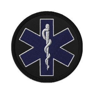 Peut inclure: Un patch rond noir avec une étoile de vie bleue et un caducée argenté au centre.