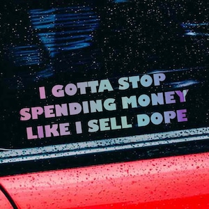 May include: A car window sticker with the text "I GOTTA STOP SPENDING MONEY LIKE I SELL DOPE" in a gradient of purple, blue, and green. The sticker is on a car window with a red car body visible.