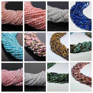 Könnte beinhalten: Sortiment an facettierten Edelsteinperlen in verschiedenen Farben, darunter rosa, blau, grün, braun und weiß. Die Perlen sind zu langen Strängen aufgereiht und eignen sich perfekt für die Schmuckherstellung.