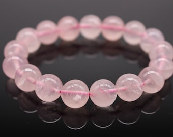 May include: A pink rose quartz beaded bracelet with a pink string connecting the beads.