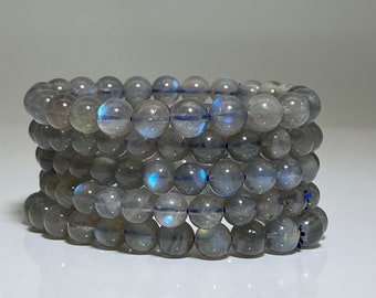 May include: A stack of five gray labradorite gemstone bracelets with iridescent blue flashes.