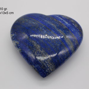 Op de afbeelding: Een hartvormige gepolijste lapis lazuli steen met blauwe en witte strepen. De steen meet 14x13x5 cm en weegt 1410 gram.