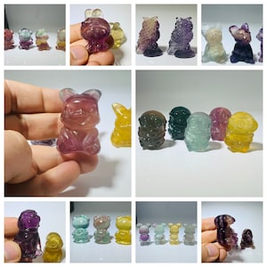 Op de afbeelding: Een verzameling kleurrijke fluorite kristallen dierenfiguren. De figuren zijn in verschillende vormen, waaronder een kat, een hond, een konijn, een beer en een vogel. De kristallen zijn allemaal in verschillende tinten paars, groen, blauw en geel.