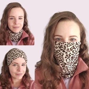 Puede incluir: Una mujer lleva una mascarilla de estampado de leopardo marrón y blanco. La mascarilla está hecha de un tejido suave y elástico y está diseñada para llevarse sobre la nariz y la boca. La mascarilla es un accesorio popular para las personas que quieren protegerse a sí mismas y a los demás de la propagación de gérmenes.
