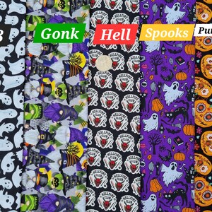 May include: Four different fabric swatches with Halloween themes. The first swatch is black with white ghost silhouettes and the text "G3". The second swatch is purple, green, and white with a gnome pattern and the text "Gonk". The third swatch is black with red and white "Hellfire Club" logos. The fourth swatch is purple with black cats, white ghosts, and orange pumpkins and the text "Spooks". The fifth swatch is black with orange and white pumpkins and the text "Pumpkins 2".